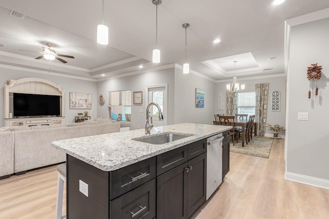 1922 Frontera St, Navarre, FL 32566 - kitchen featuring a raised ceiling, stainless steel dishwasher, light wood finished floors, a kitchen island with sink, and recessed lighting
