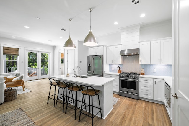 213 Spotted Dolphin Rd, Santa Rosa Beach, FL 32459 - kitchen featuring stainless steel appliances, ventilation hood, a breakfast bar, backsplash, and light wood finished floors