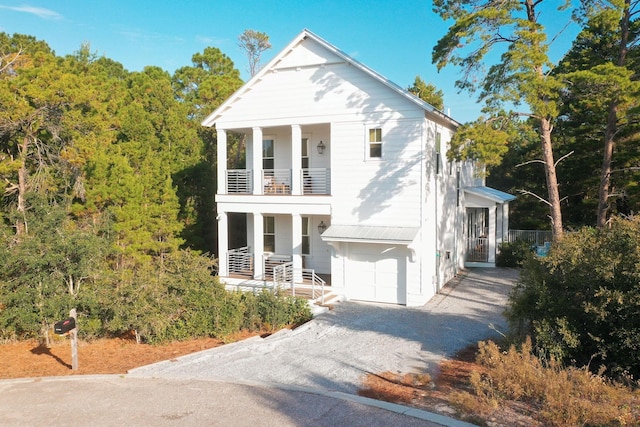 213 Spotted Dolphin Rd, Santa Rosa Beach, FL 32459 - greek revival inspired property featuring a balcony, gravel driveway, a garage, and a porch