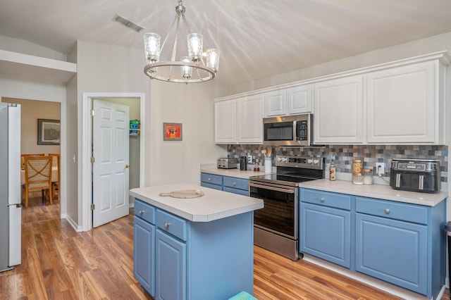 337 Peggy Dr, Crestview, FL 32536 - kitchen with stainless steel appliances, blue cabinetry, a chandelier, and decorative backsplash