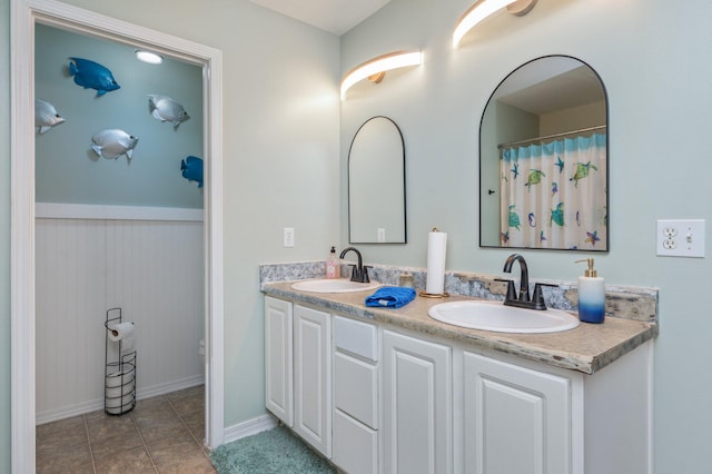 337 Peggy Dr, Crestview, FL 32536 - bathroom featuring double vanity, a wainscoted wall, and tile patterned floors