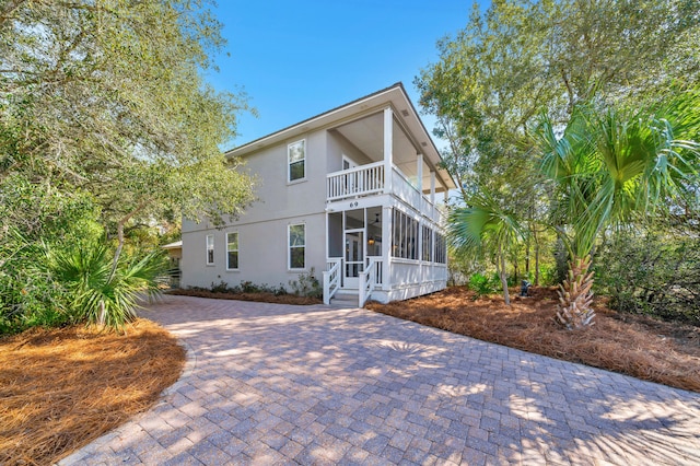 69 Lake Pointe Dr, Santa Rosa Beach, FL 32459 - back of property with a balcony, stucco siding, and a sunroom