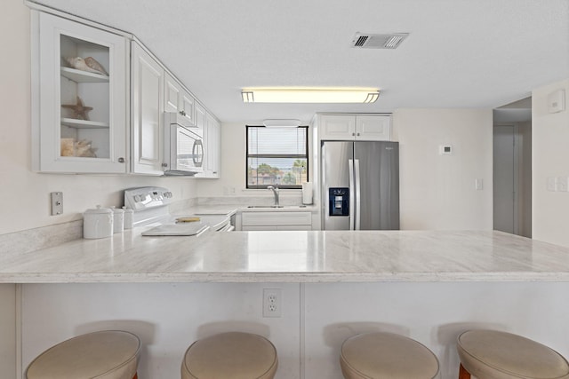 3705 E Old Highway 98 # 6, Destin, FL 32541 - kitchen featuring white microwave, stainless steel fridge with ice dispenser, stove, glass insert cabinets, and a peninsula