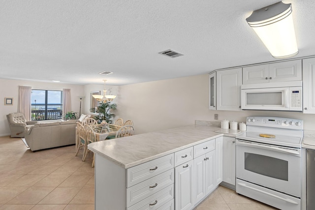 3705 E Old Highway 98 # 6, Destin, FL 32541 - kitchen with white appliances, a peninsula, light countertops, light tile patterned floors, and a textured ceiling
