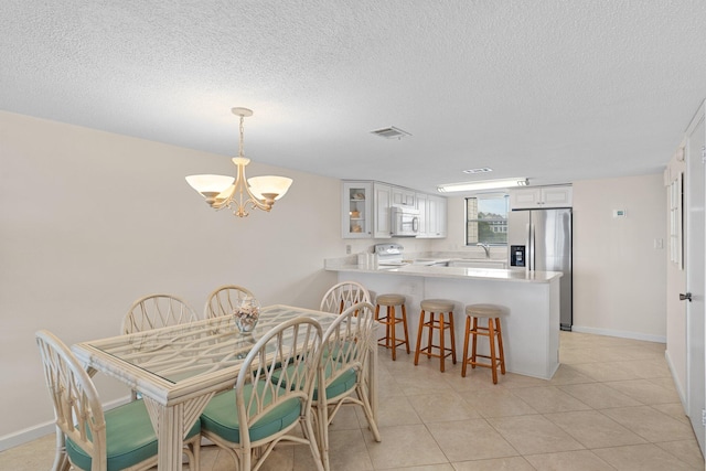3705 E Old Highway 98 # 6, Destin, FL 32541 - dining room with a chandelier, a textured ceiling, and light tile patterned floors