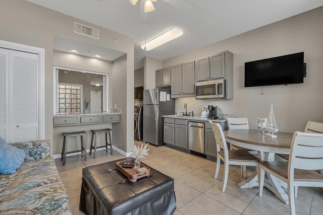 1517 SW Miracle Strip Pkwy Unit 309, Fort Walton Beach, FL 32548 - kitchen featuring stainless steel appliances, gray cabinets, ceiling fan, and light tile patterned flooring