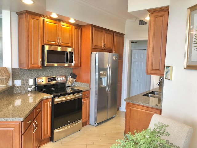 1096 Scenic Gulf Dr Unit 1512, Miramar Beach, FL 32550 - kitchen with appliances with stainless steel finishes, brown cabinetry, decorative backsplash, ornamental molding, and light stone counters