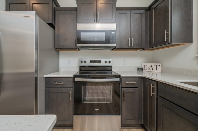 2940 Mccarty Ave, Crestview, FL 32539 - kitchen with appliances with stainless steel finishes, dark brown cabinetry, and light wood-style floors
