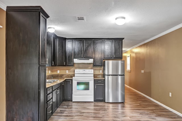 155 Caswell Branch Rd, Freeport, FL 32439 - kitchen with white range with electric stovetop, freestanding refrigerator, under cabinet range hood, crown molding, and wood finished floors