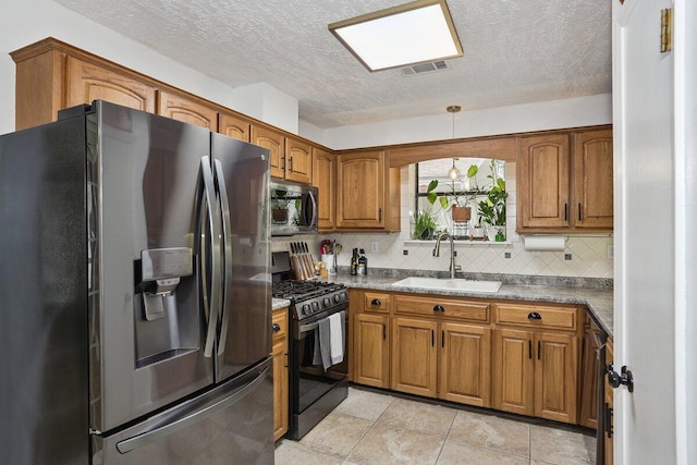 107 Shell Dr, Crestview, FL 32536 - kitchen featuring appliances with stainless steel finishes, brown cabinets, decorative backsplash, a textured ceiling, and light tile patterned flooring