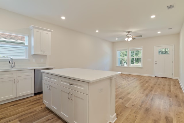 6109 Tansey St, Crestview, FL 32539 - kitchen with dishwasher, a ceiling fan, light countertops, light wood-style flooring, and white cabinets