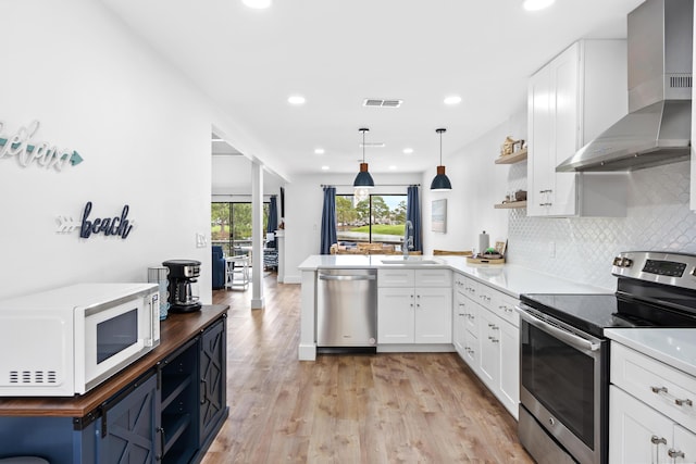 431 Linkside Cir, Miramar Beach, FL 32550 - kitchen featuring stainless steel appliances, wall chimney exhaust hood, open shelves, white cabinetry, and recessed lighting