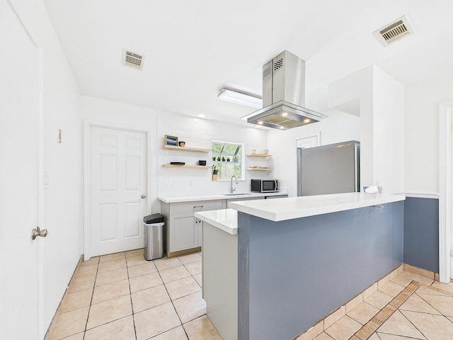 422 John King Rd, Crestview, FL 32539 - kitchen with stainless steel appliances, light tile patterned floors, open shelves, island range hood, and a peninsula