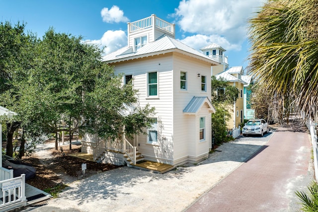 54 Roberts Way, Santa Rosa Beach, FL 32459 - view of side of home with driveway, a metal roof, and a balcony