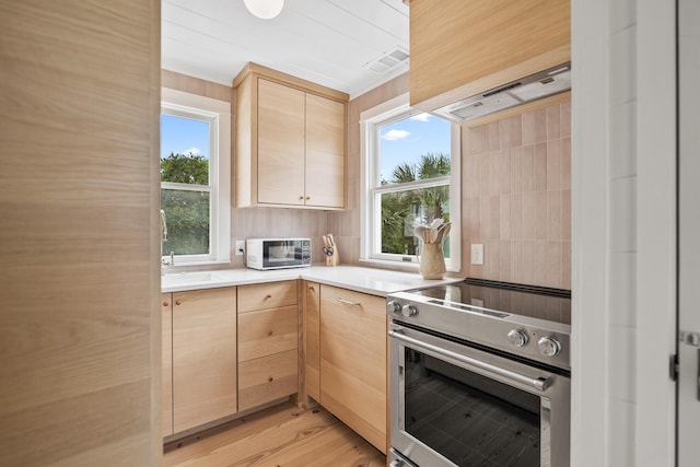 54 Roberts Way, Santa Rosa Beach, FL 32459 - kitchen with stainless steel range with electric stovetop, light brown cabinetry, light countertops, and light wood-style flooring