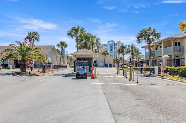 134 Damon Cir Unit Q, Panama City Beach, FL 32407 - view of asphalt street with traffic signs, a gated entry, a residential view, and curbs