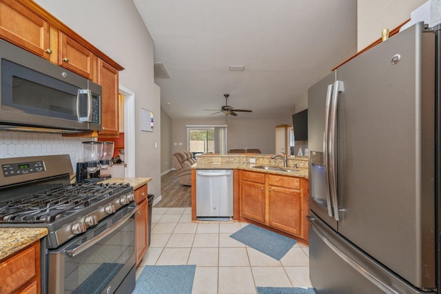 80 Azalea Trce, Defuniak Springs, FL 32433 - kitchen with appliances with stainless steel finishes, open floor plan, brown cabinetry, and ceiling fan