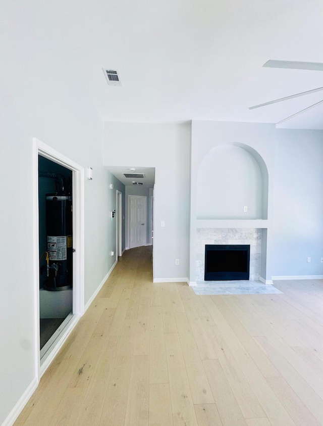 1198 Saddle Creek Dr, Fort Walton Beach, FL 32547 - unfurnished living room with light wood-type flooring, a high end fireplace, and water heater