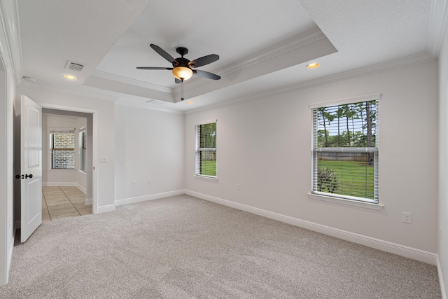 7478 Brevard St, Navarre, FL 32566 - empty room with ornamental molding, light colored carpet, a tray ceiling, healthy amount of natural light, and a ceiling fan