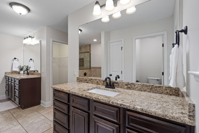 7478 Brevard St, Navarre, FL 32566 - bathroom featuring vanity, tile patterned floors, tiled shower, and a walk in closet