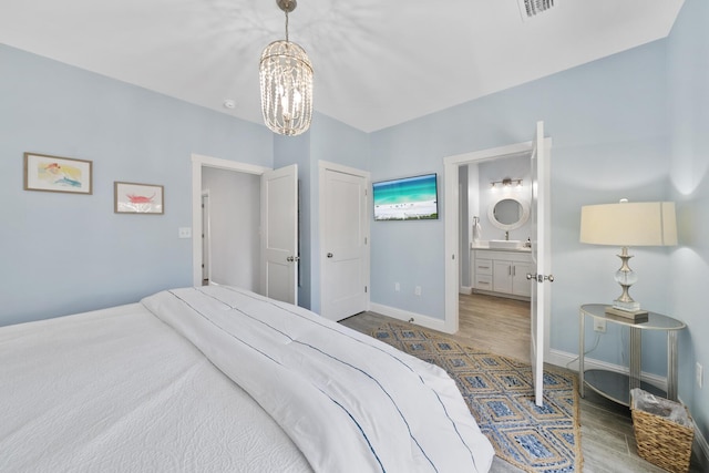 115 N Barcelona Ave, Santa Rosa Beach, FL 32459 - bedroom with wood finished floors, a chandelier, and ensuite bathroom