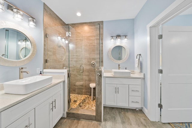 115 N Barcelona Ave, Santa Rosa Beach, FL 32459 - bathroom featuring wood finished floors, two vanities, a shower stall, and recessed lighting