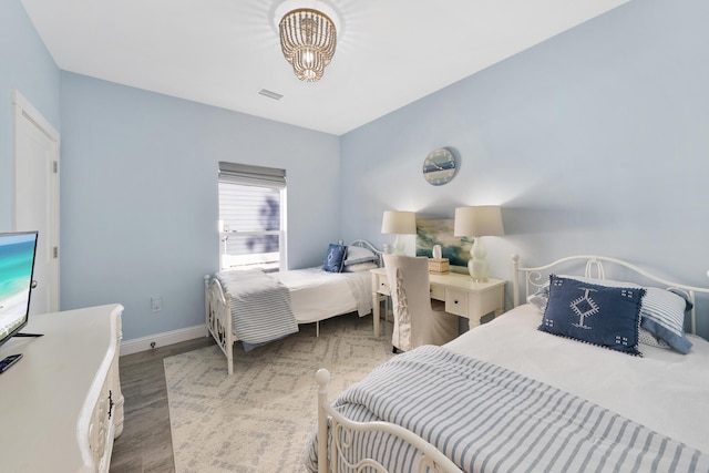 115 N Barcelona Ave, Santa Rosa Beach, FL 32459 - bedroom featuring wood finished floors and a chandelier