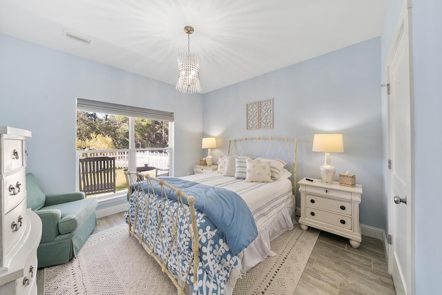 115 N Barcelona Ave, Santa Rosa Beach, FL 32459 - bedroom featuring a chandelier, light wood finished floors, and access to outside