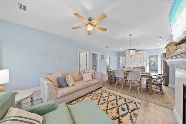 115 N Barcelona Ave, Santa Rosa Beach, FL 32459 - living room with light wood-style flooring, a ceiling fan, and a fireplace