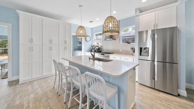 115 N Barcelona Ave, Santa Rosa Beach, FL 32459 - kitchen with stainless steel fridge, washer and dryer, light countertops, a kitchen island with sink, and white cabinets