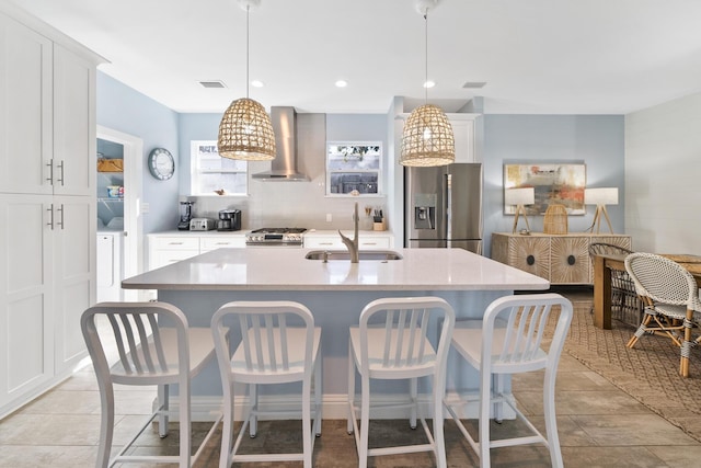115 N Barcelona Ave, Santa Rosa Beach, FL 32459 - kitchen featuring wall chimney exhaust hood, stainless steel appliances, white cabinetry, a kitchen breakfast bar, and recessed lighting