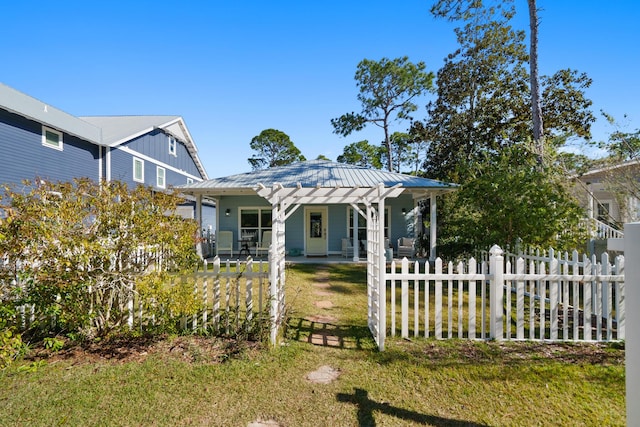 115 N Barcelona Ave, Santa Rosa Beach, FL 32459 - view of front of home with a porch, a fenced front yard, board and batten siding, and a metal roof