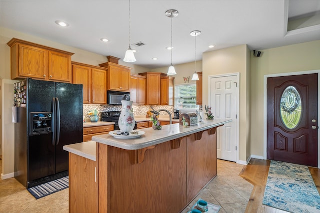 4820 Griffith Rd, Holt, FL 32564 - kitchen with black appliances, backsplash, light countertops, a breakfast bar, and brown cabinets