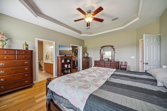 4820 Griffith Rd, Holt, FL 32564 - bedroom with light wood-style floors, a tray ceiling, a spacious closet, a closet, and connected bathroom