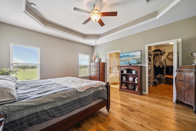 4820 Griffith Rd, Holt, FL 32564 - bedroom with a raised ceiling, a walk in closet, light wood finished floors, a closet, and connected bathroom