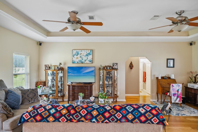 4820 Griffith Rd, Holt, FL 32564 - living area featuring a ceiling fan, wood finished floors, a tray ceiling, and arched walkways