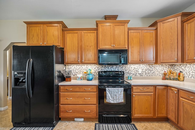 4820 Griffith Rd, Holt, FL 32564 - kitchen with black appliances, light countertops, tasteful backsplash, and brown cabinets