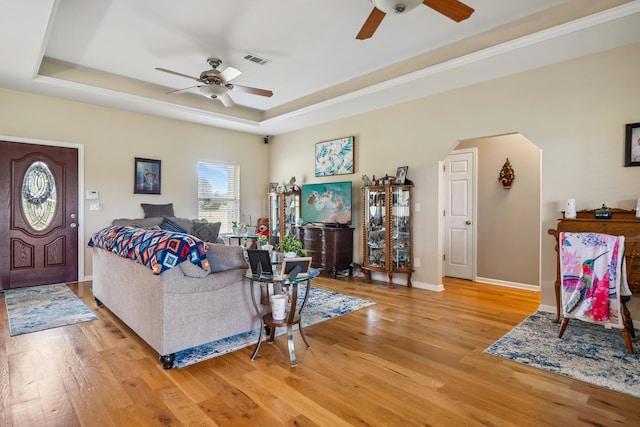 4820 Griffith Rd, Holt, FL 32564 - living room featuring ceiling fan, light wood-style flooring, arched walkways, and a tray ceiling