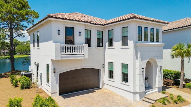1831 Tuscana Pl, Miramar Beach, FL 32550 - mediterranean / spanish-style home featuring a balcony, an attached garage, stucco siding, and a water view