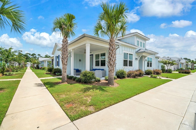 8546 Dreams Float Ct, Panama City Beach, FL 32413 - view of front of property featuring board and batten siding, covered porch, a front yard, and ceiling fan