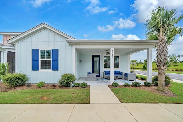 8546 Dreams Float Ct, Panama City Beach, FL 32413 - view of front of property featuring board and batten siding, outdoor lounge area, covered porch, and a front yard