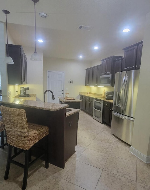 114 S Knightsbridge Ct, Santa Rosa Beach, FL 32459 - kitchen with stainless steel appliances, a peninsula, light stone countertops, a kitchen breakfast bar, and decorative light fixtures