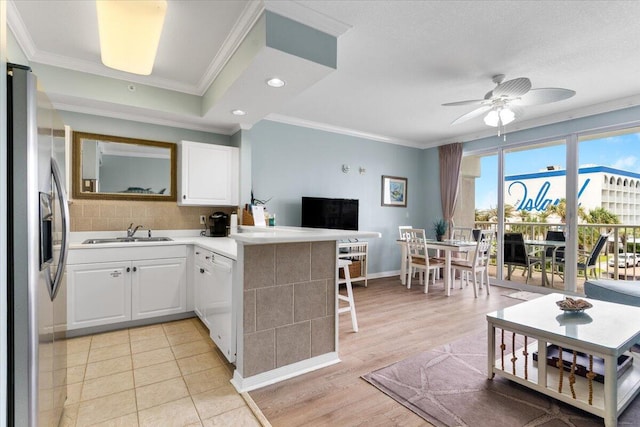 1515 SE Miracle Strip Pkwy Unit 305, Fort Walton Beach, FL 32548 - kitchen with stainless steel fridge, a peninsula, white cabinets, ornamental molding, and ceiling fan