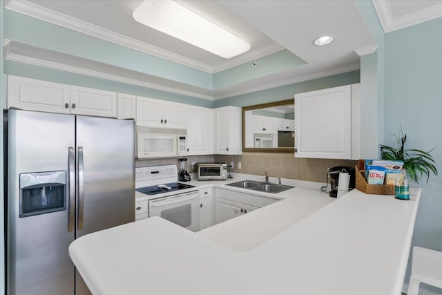 1515 SE Miracle Strip Pkwy Unit 305, Fort Walton Beach, FL 32548 - kitchen featuring white appliances, crown molding, a peninsula, tasteful backsplash, and white cabinets