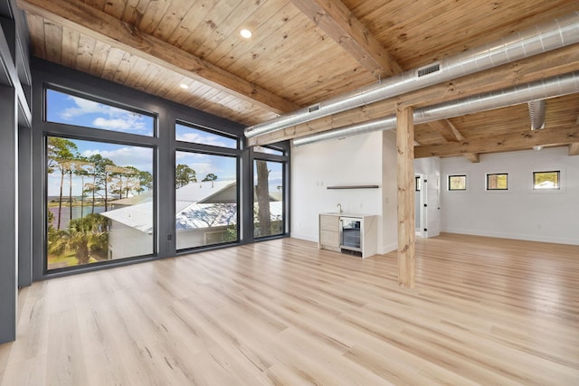129 Oyster Lake Dr, Santa Rosa Beach, FL 32459 - unfurnished living room featuring a wooden ceiling with exposed beams, wood finished floors, expansive windows, and beverage cooler
