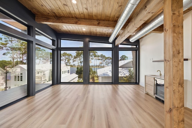 129 Oyster Lake Dr, Santa Rosa Beach, FL 32459 - unfurnished living room with wine cooler, a wall of windows, wood finished floors, bar, and a wooden ceiling with exposed beams
