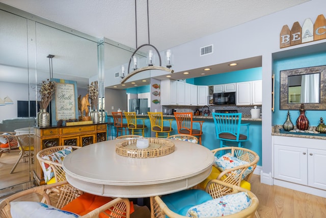 8520 Gulf Blvd Unit 29, Navarre, FL 32566 - dining space featuring light wood-type flooring and a textured ceiling