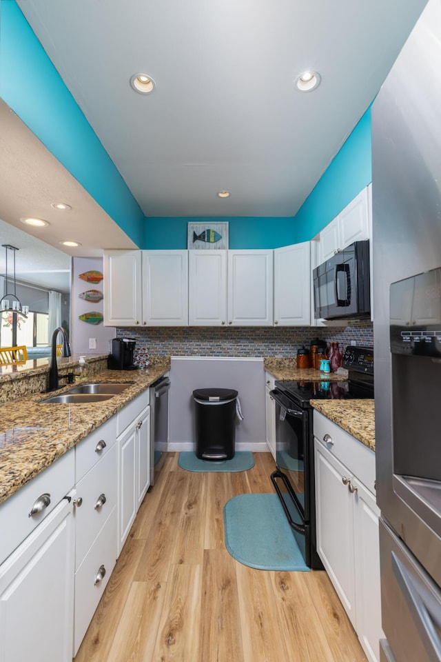 8520 Gulf Blvd Unit 29, Navarre, FL 32566 - kitchen with black appliances, white cabinets, backsplash, light wood-style floors, and recessed lighting