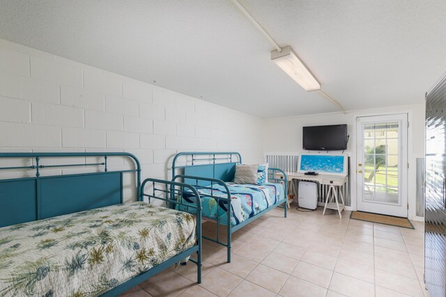 8520 Gulf Blvd Unit 29, Navarre, FL 32566 - bedroom featuring access to outside, concrete block wall, and tile patterned flooring