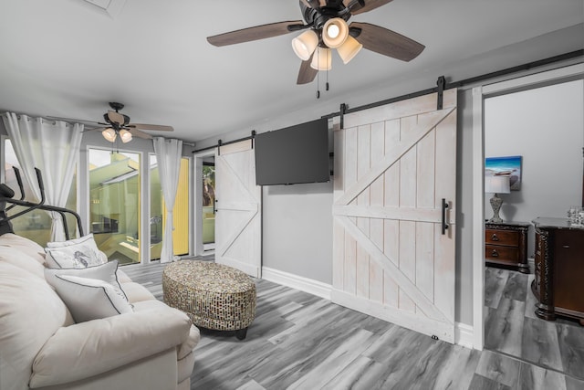 8520 Gulf Blvd Unit 29, Navarre, FL 32566 - living area featuring a barn door, ceiling fan, and wood finished floors
